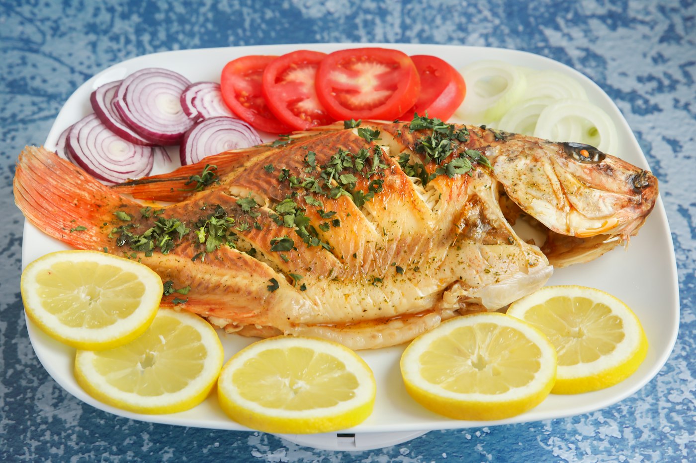 Pescado al horno con limón, jitomate y cebolla